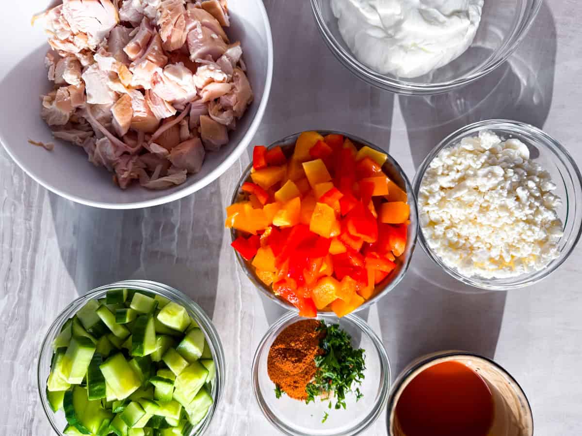 Ingredients for the buffalo chicken salad prepared in separate bowls.