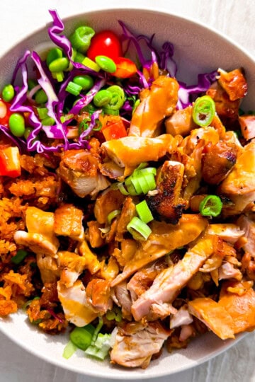Bowl filled with chicken, crispy rice, and veggies.
