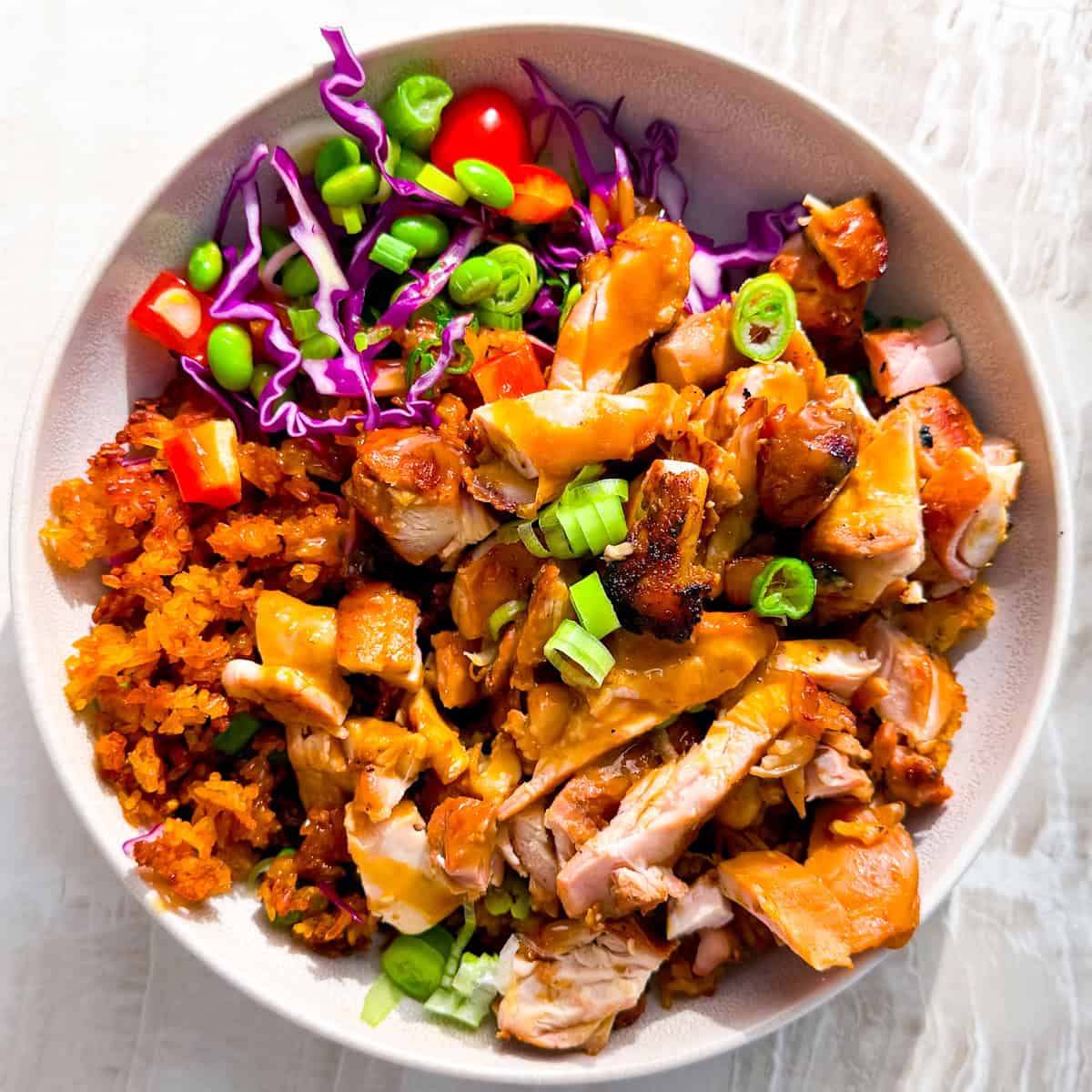 Asian crispy rice bowls filled with chicken, crispy rice, and veggies.