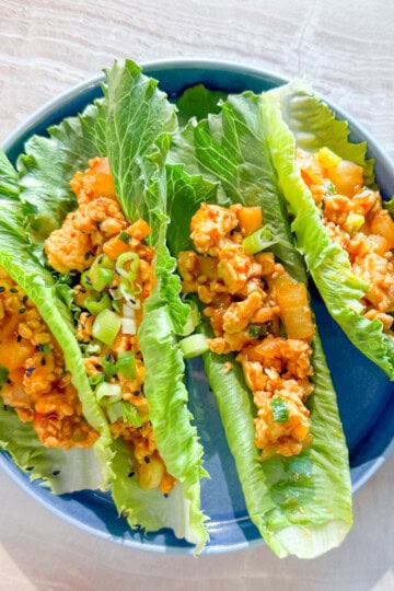 Finished photo of four chicken lettuce wraps in lettuce cups.