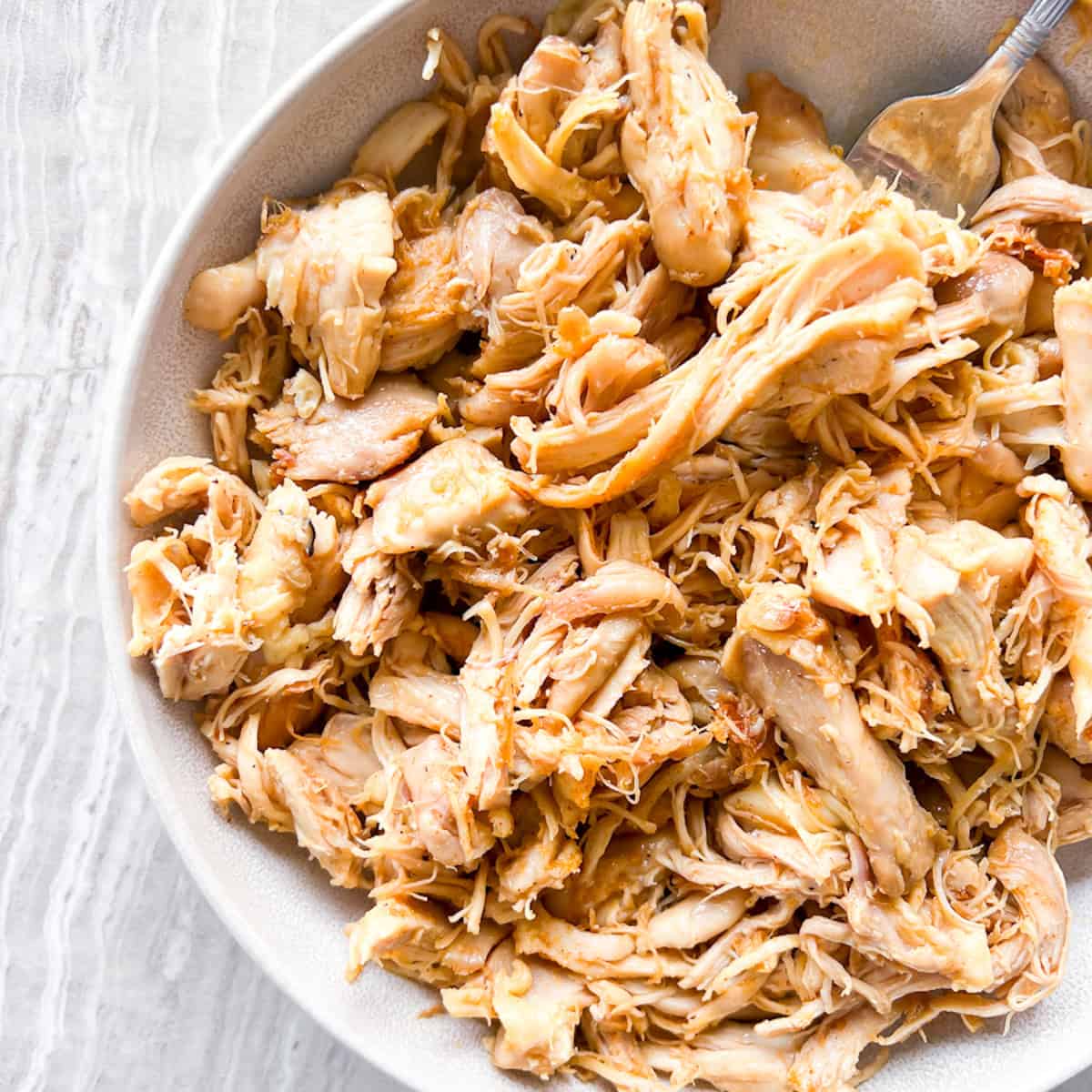Dutch oven shredded chicken on a white plate.