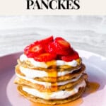Stacked pancakes topped with greek yogurt and strawberries.