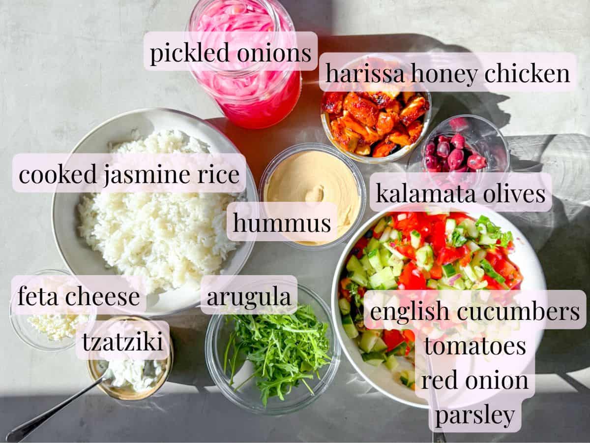 Harissa honey chicken bowl ingredients labeled in clear bowls.