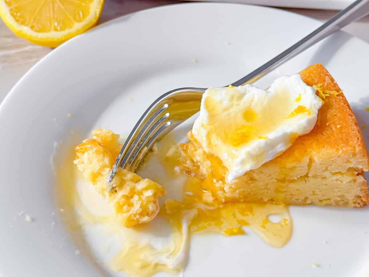 Lemon olive oil cake with a bite taken out of it.