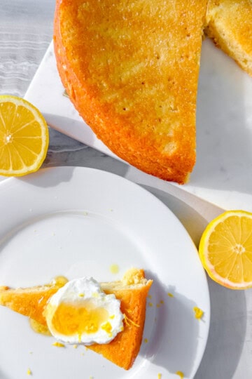 Lemon olive oil slice next to the whole cake.