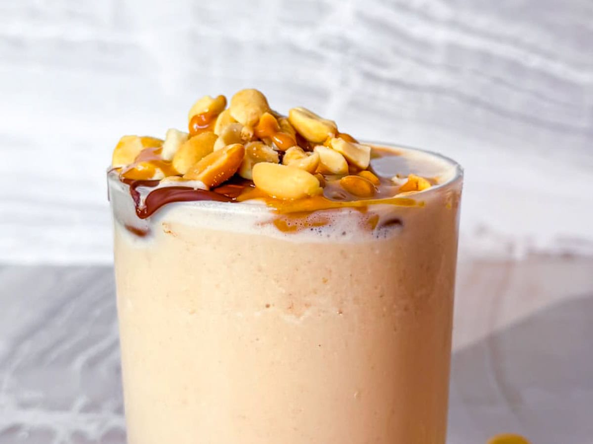 Peanut butter smoothie without banana topped with peanuts and chocolate.