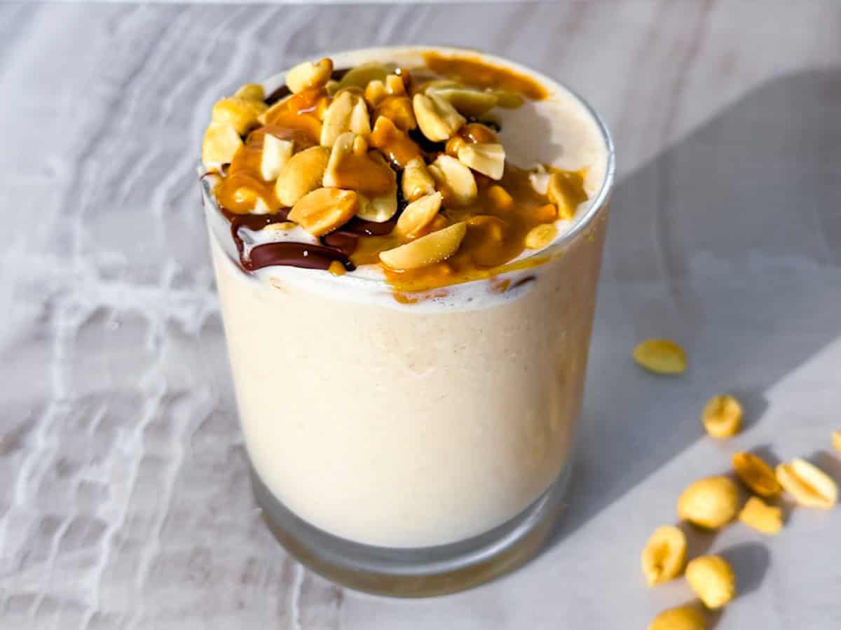 Peanut butter smoothie without banana topped with peanuts and chocolate.