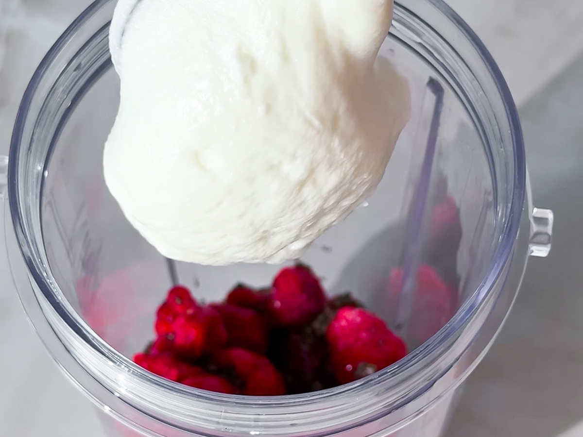 Raspberry chia pudding ingredients being put in the blender.