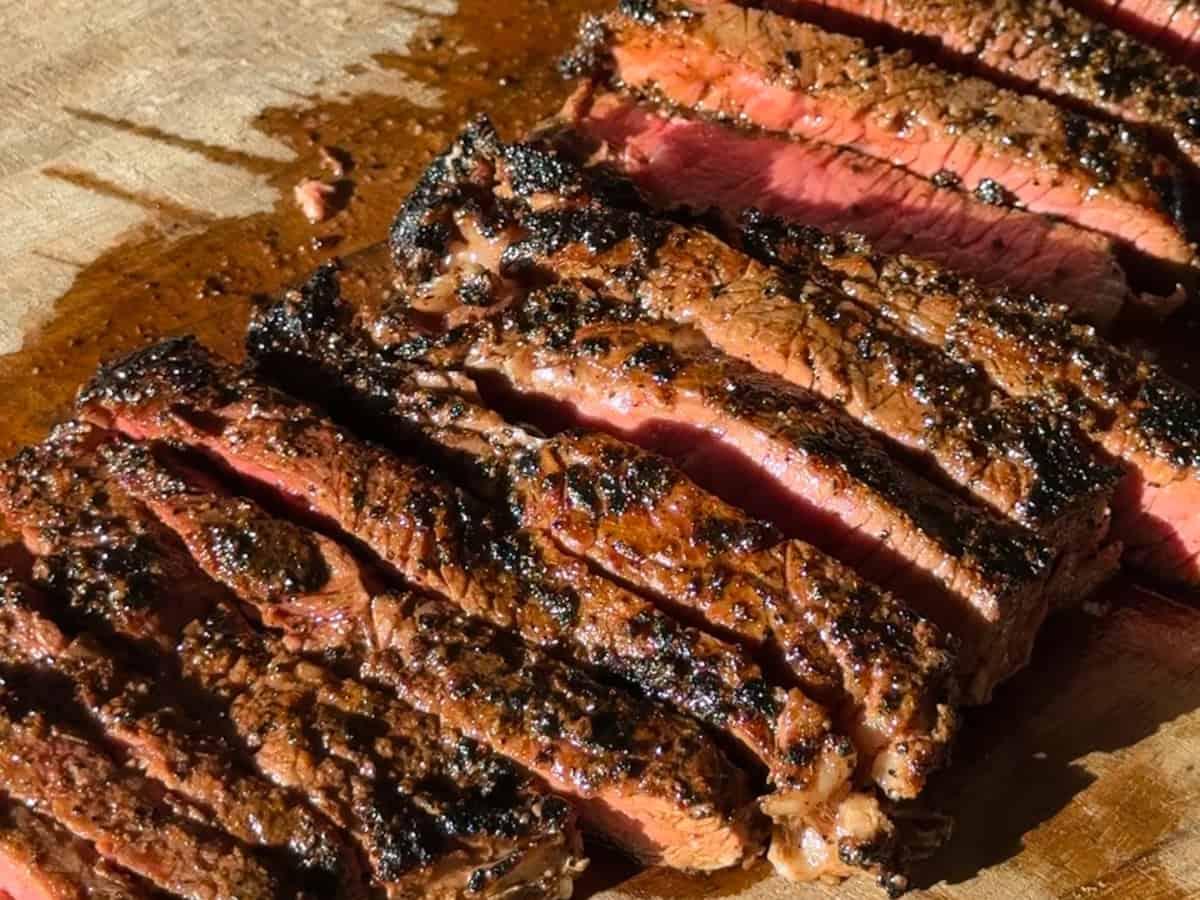 Steak sliced into strips on a wooden cutting board.