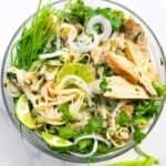 Asian soup with chicken in a clear bowl.