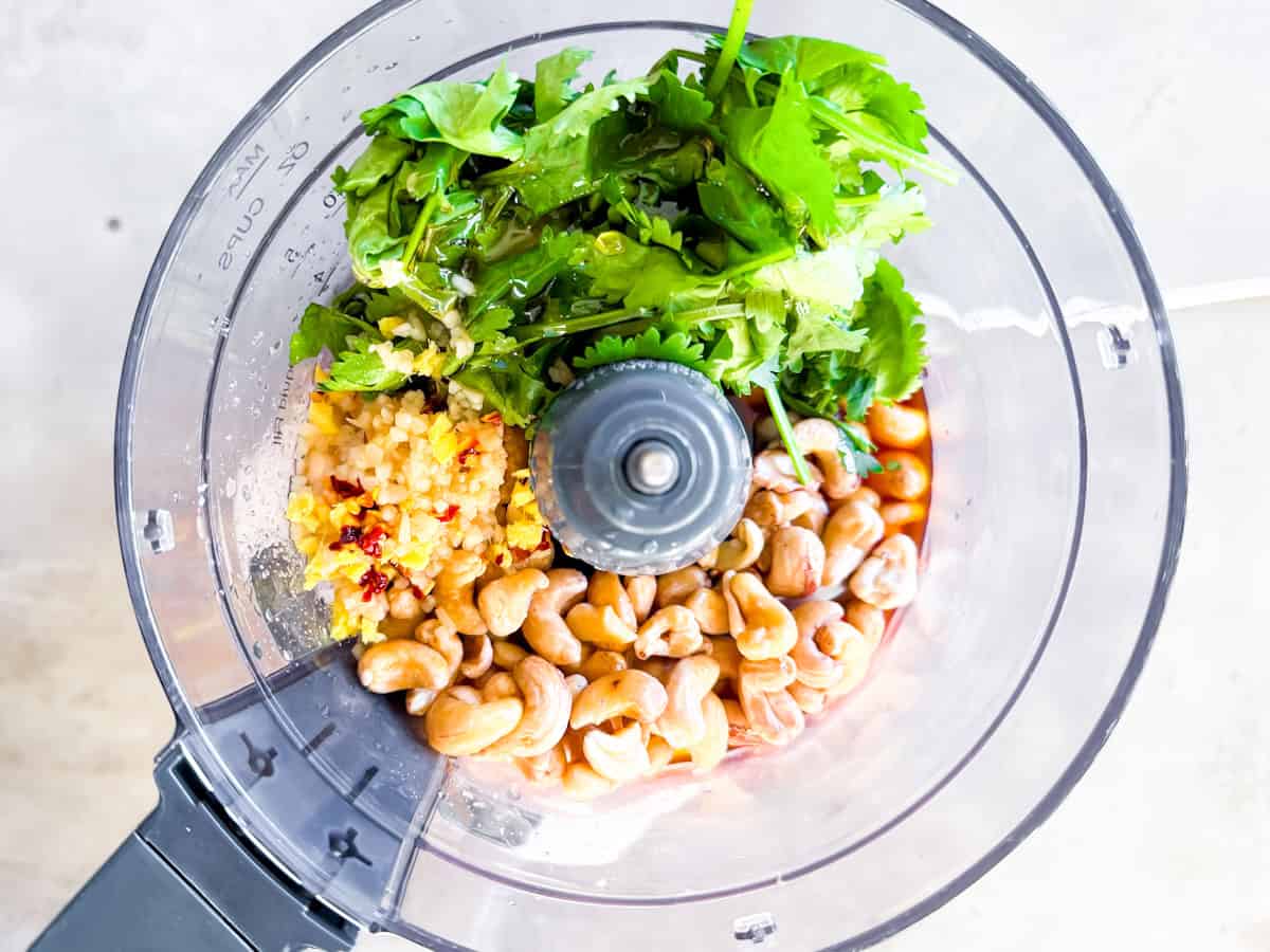 Cashews, cilantro, ginger garlic, tamari, and other dressing ingredients in the food processor.