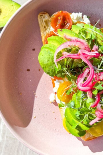 Cottage cheese and avocado toast with pickled onions and micro greens.