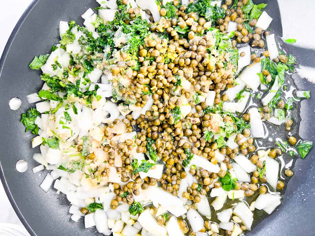 Aromatics being sautéed in a pan.