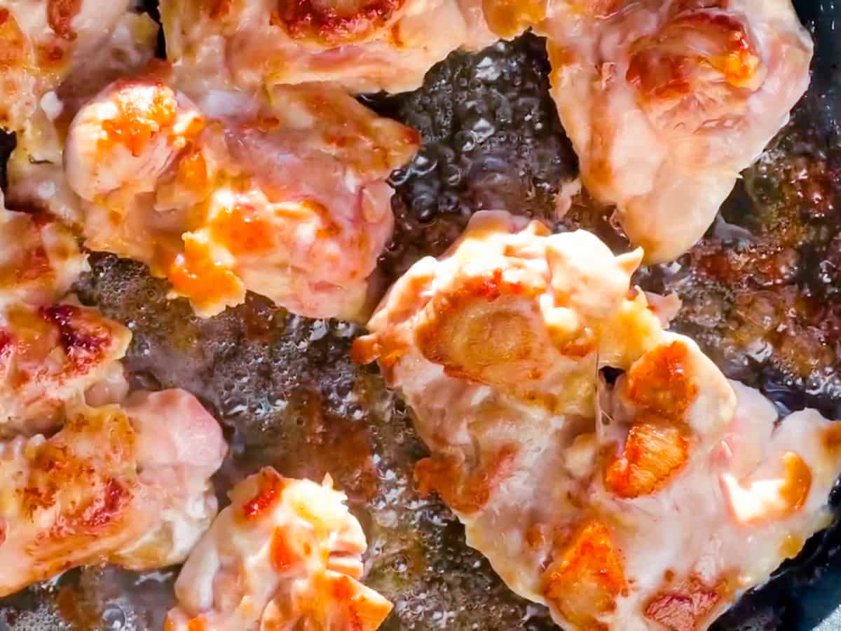 Chicken being cooked in a pan.