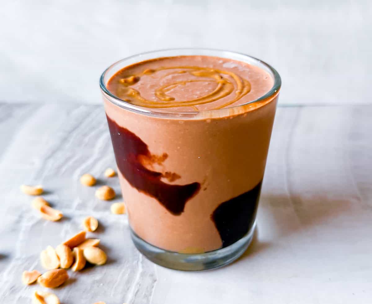 Finished peanut butter banana smoothie in a cup lined with chocolate.
