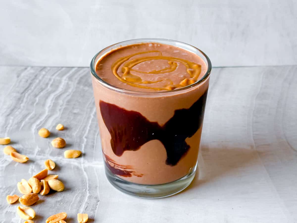 Finished peanut butter banana smoothie in a cup lined with chocolate.