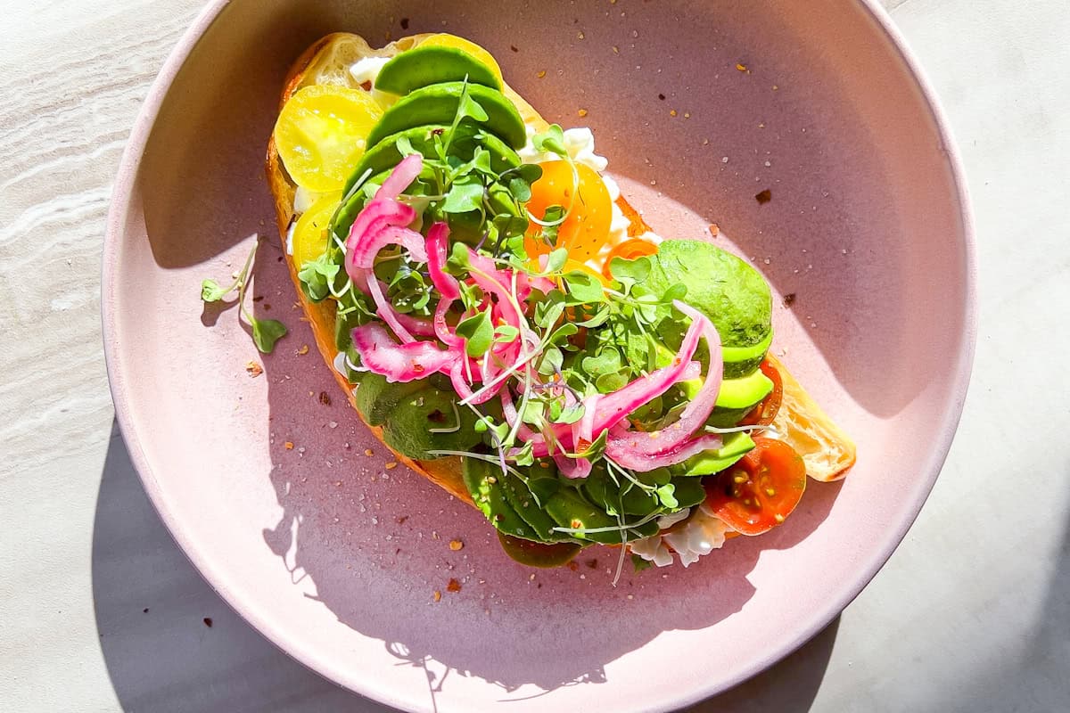 Finished cottage cheese avocado toast on a pink plate.