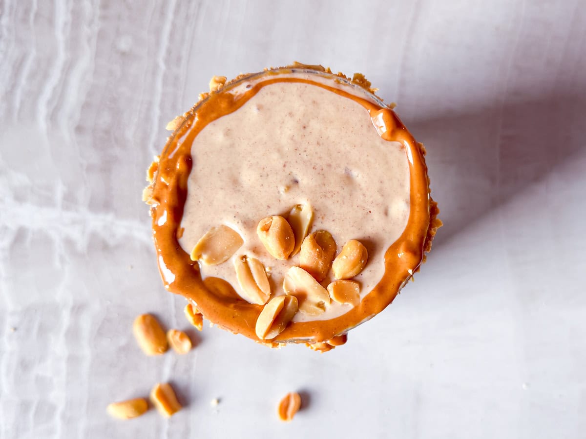 Overhead shot of a peanut butter smoothie topped with peanuts.