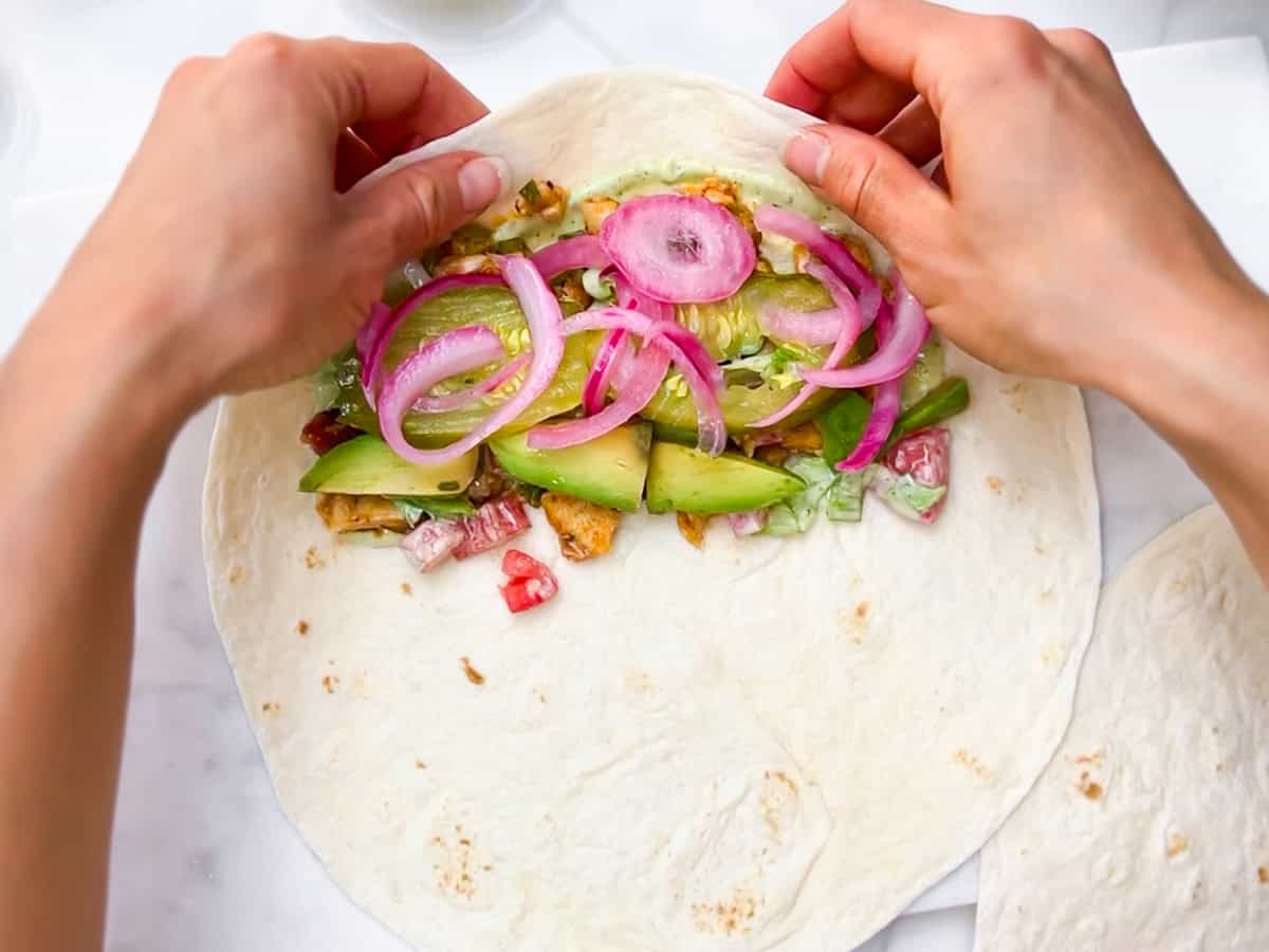 Buffalo chicken wrap being folded.