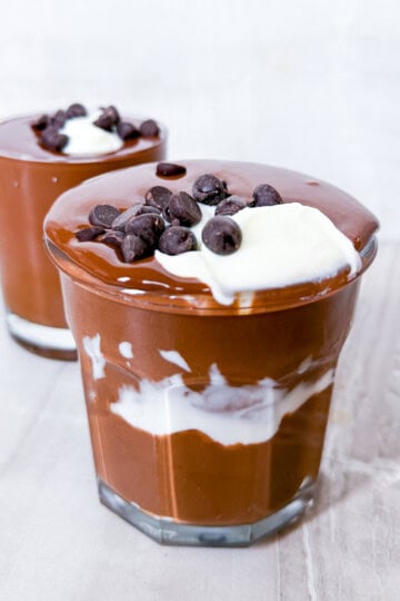Finished Cottage Cheese Chocolate Mousse topped with greek yogurt and chocolate in clear cups.