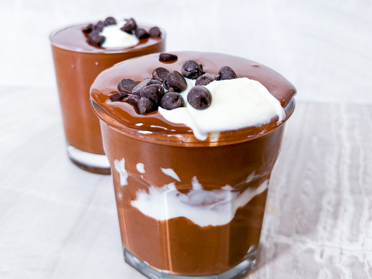 Finished Cottage Cheese Chocolate Mousse topped with greek yogurt and chocolate in clear cups.