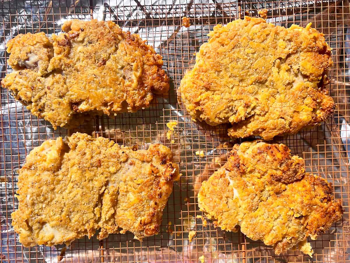 Gluten free chicken parmesan part way cooked on a wire rack.
