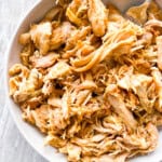 Dutch oven shredded chicken on a white plate.