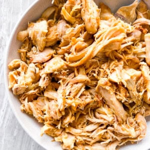 Dutch oven shredded chicken on a white plate.